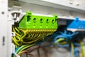 Green-yellow self-locking block for the grounding electric wire, mounted in the electric box with connected cables. Royalty Free Stock Photo