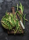 Green and yellow string beans on a wooden chopping board on a dark background, top view Royalty Free Stock Photo
