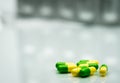 Green, yellow tramadol capsule pills on blurred silver blister p Royalty Free Stock Photo