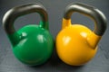 Green and yellow weightlifting kettlebells in a gym