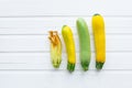 Green and yellow zucchini. Fresh vegetables. On a white wooden table. View from above Royalty Free Stock Photo