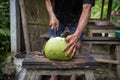 Green young fresh coconut cutting with heavy chop knife