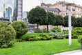 Greenery in a city park with pillar lantern on a green lawn. Royalty Free Stock Photo