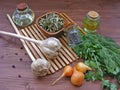 Greenery : fresh parsley and dill, onion, garlic, olive oil in glass, dry spices in bowl and juniper berries on wooden table Royalty Free Stock Photo