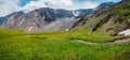 Greenery mountain landscape of motley mountain valley with river in sunlight. Wonderful sunny highland scenery of multicolor