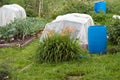 Greenhouses, covered with a polyethylene film and blue plastic barrels for water, stand in the garden. Royalty Free Stock Photo