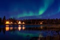 Greenish Aurora Borealis over illuminated Tipi near a lake, Yellow knife