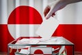 Greenland flag, hand dropping ballot card into a box - voting, election concept