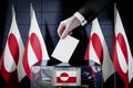 Greenland flags, hand dropping ballot card into a box - voting, election concept