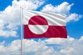 Greenland national flag waving in the wind on clouds sky. High quality fabric. International relations concept Royalty Free Stock Photo