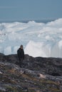 Greenland tourist man explorer overlooking Icefjord in Ilulissat. Travel in arctic landscape nature with icebergs Royalty Free Stock Photo