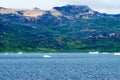 Greenlandic coastline with uninhabitated mountains and icebergs in Arctic Ocean