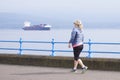 Greenock, Inverclyde / Scotland - July 11th 2019: Woman running as healthy active lifestyle at sea coast esplanade pathGreenock, I