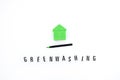 Greenwashing concept with green and black pen and plastic house. Greenwashing marketing ploy products seem more