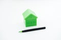 Greenwashing concept with green and black pen and plastic house. Greenwashing marketing ploy products seem more