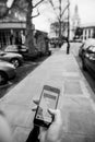 Woman waiting for the uber car on the street holding smartphone Royalty Free Stock Photo