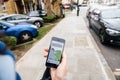 Woman waiting for the uber car on the street holding smartphone Royalty Free Stock Photo