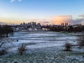 Greenwich obervatory college hill walk park snow winter evening sunset orange warm light clouds view London city skyline Royalty Free Stock Photo