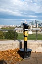 Talking telescope on an observation deck in Greenwich Royal Park with a view on Queen`s house and London city