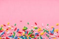 Background of colorful sprinkles over pink, festive invitation for Valentines day, birthday, holiday and party time, copy