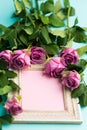 Greeting card with beautiful wooden vintage picture frame, fresh pink roses and copy space.