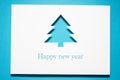 Greeting card with a blue Christmas tree cut out of paper. Silhouette of a fir tree. Royalty Free Stock Photo