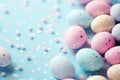 Greeting card with colorful Easter eggs and confetti on a pastel blue background Royalty Free Stock Photo