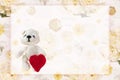 A greeting card with a crochet tiny bear holding a crochet handmade heart for Valentines day. Tender romantic vintage background w