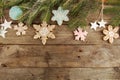 Greeting card with decor gingerbread cookies snowflakes, fir tree branch on old wooden background. Overhead of Christmas New Year Royalty Free Stock Photo