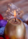 Greeting card Easter burning golden candle. Festive easter concept of candle and yellow eggs on a wooden table.