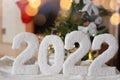 a greeting card with a happy new year 2022 on the background of a fireplace, a Christmas tree, with bright lights of a Royalty Free Stock Photo