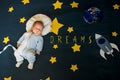 Greeting card with the inscription Dreams. Boy baby sleeping astronaut on the background of the starry sky Royalty Free Stock Photo