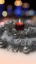 Greeting card made of silver tinsel with silver christmas balls, red burning candle and bokeh lights at background Royalty Free Stock Photo