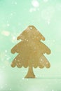 Greeting card in minimal style. Wooden Christmas tree on blue background with copy space, lights bokeh, snow. New Year party. Royalty Free Stock Photo