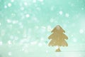 Greeting card in minimal style. Wooden Christmas tree on blue background with copy space, lights bokeh, snow. New Year party. Royalty Free Stock Photo