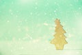 Greeting card in minimal style. Wooden Christmas tree on blue background with copy space, lights bokeh, snow. New Year party. Royalty Free Stock Photo