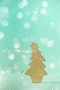 Greeting card in minimal style. Wooden Christmas tree on blue background with copy space, lights bokeh, snow. New Year party. Royalty Free Stock Photo