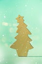 Greeting card in minimal style. Wooden Christmas tree on blue background with copy space, lights bokeh, snow. New Year party. Royalty Free Stock Photo