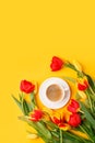 Greeting card mockup. Bouquet of colorful tulip flowers, cup of coffee on yellow background, copy space, invitation. Spring Royalty Free Stock Photo