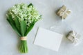 Greeting card mockup. Bouquet of lilies of the valley, postcard, gift boxes on a light blue background Royalty Free Stock Photo