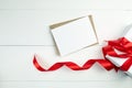 Greeting card mockup with paper envelope and red ribbon and gift box on white table Royalty Free Stock Photo