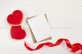 Greeting card mockup with paper envelope and red ribbon and heart shaped ginger snap cookie on white table Royalty Free Stock Photo