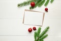 Greeting card mockup with red christmas decorations and fir tree branches on white background Royalty Free Stock Photo