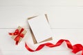 Greeting card mockup with paper envelope and red ribbon and gift box on white table Royalty Free Stock Photo