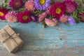 Greeting card with multicolored asters daisies, craft gift box on old blue paint wooden background; Royalty Free Stock Photo