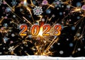 A greeting card for the new year. Sparkling numbers 2023 on the black night sky with falling snowflakes. Festive background. Royalty Free Stock Photo