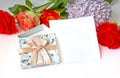 Greeting card with open giftbox with ribbon and bow on a white background with red roses Royalty Free Stock Photo