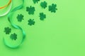 Greeting card for saint Patrick's day. Paper clover leaves with ribbons on green background, copyspace