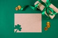 Greeting card for St. Patrick's Day on a green background. Gold coins, shamrock and gift. Happy Irish holiday. Royalty Free Stock Photo