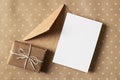 Greeting card stationary mockup with gift box and envelope on craft paper background Royalty Free Stock Photo